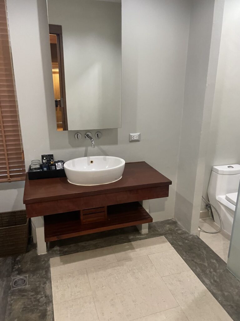 Wooden vanity with vessel sink and mirror in the Deluxe Twin Pool-Access bathroom