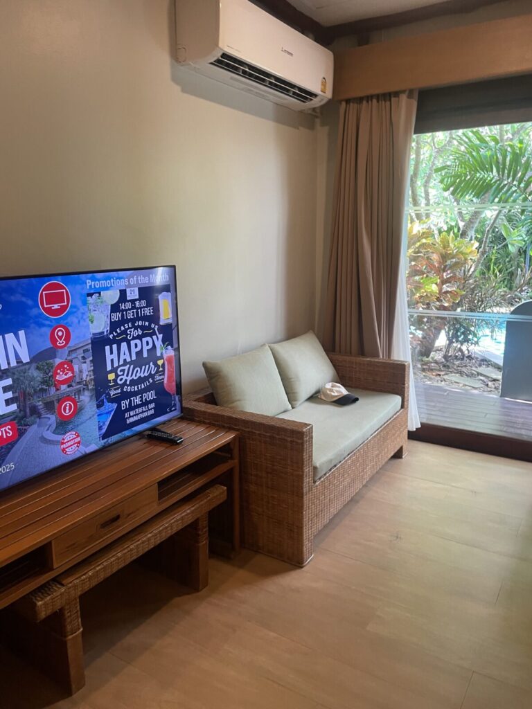 Small sofa and TV corner beside the terrace door in the Deluxe Twin Pool-Access room