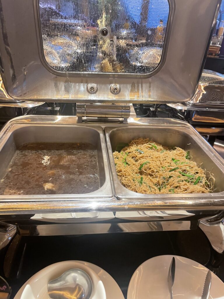 Chafing dish with clear soup on the left and stir-fried vermicelli noodles on the right