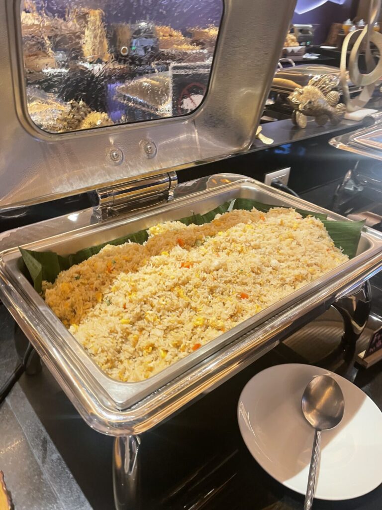 Large tray of fried rice with corn and diced vegetables.