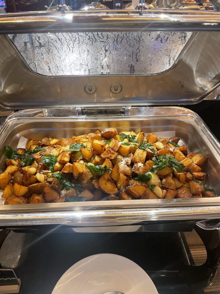 Tray of elbow macaroni tossed in red sauce with basil leaves