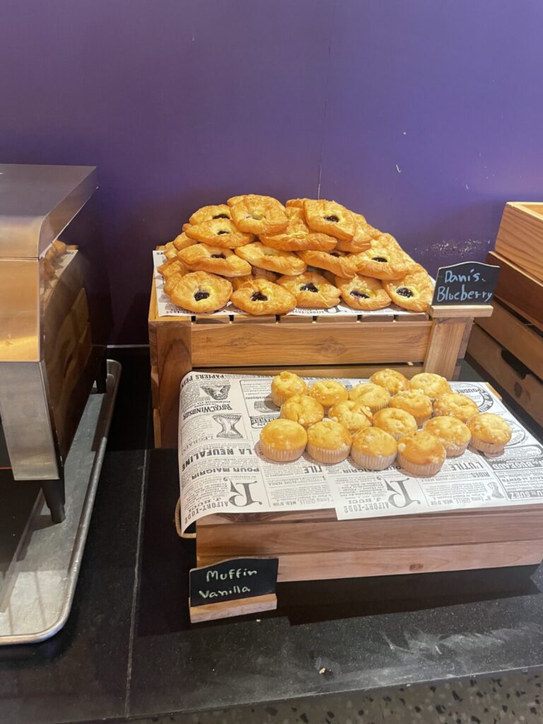 Tray of mini vanilla muffins and a stack of blueberry Danish pastries.