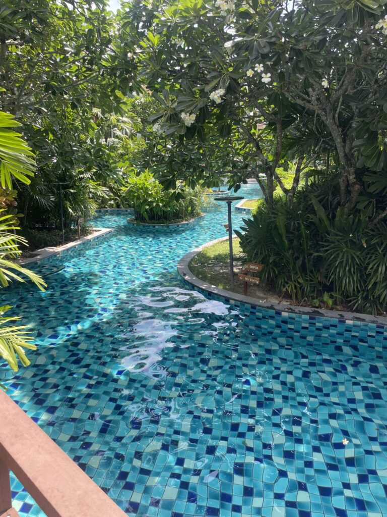Lagoon-style canal pool shaded by frangipani trees
