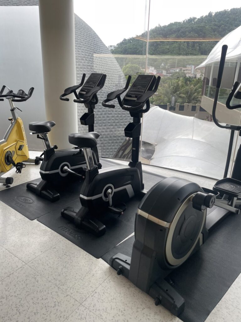 Cardio zone with bikes and rower facing large windows
