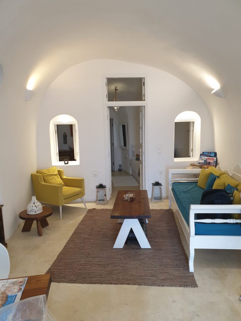 Cave house living room with arched ceiling sofa and coffee table at Anemi House Oia