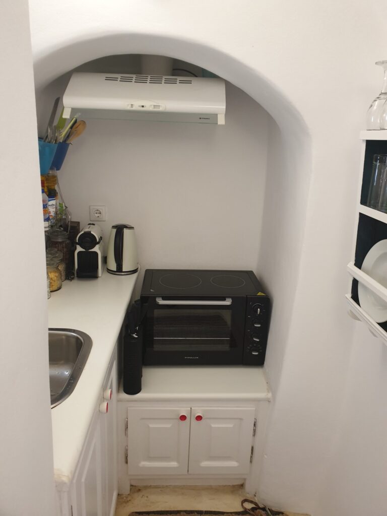 Small kitchenette with coffee maker and oven at Anemi House Oia