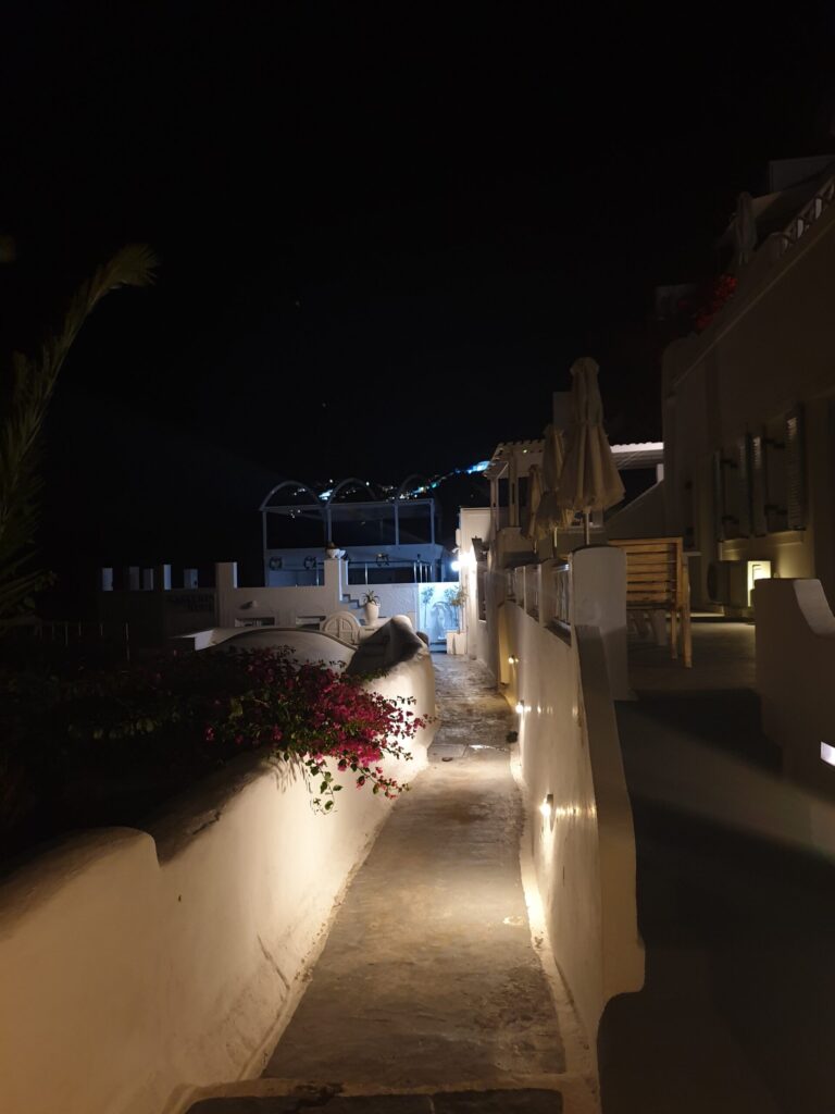 Night alley in Oia Santorini with soft lights and whitewashed walls